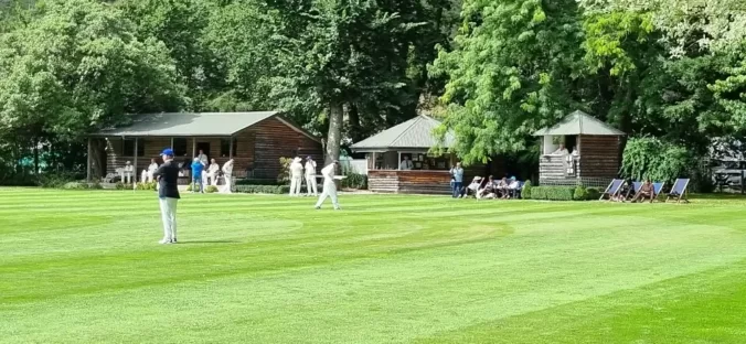 Cricket ground with pavilions and players in white