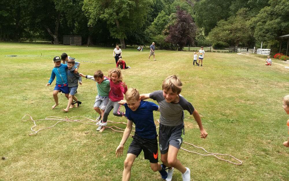 children running in a three-legged race on lawn