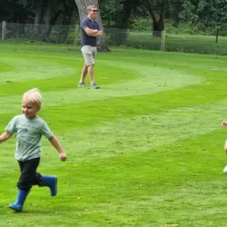 Two children running on the grass
