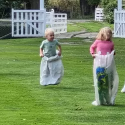 Children about to run in a sack race on grass